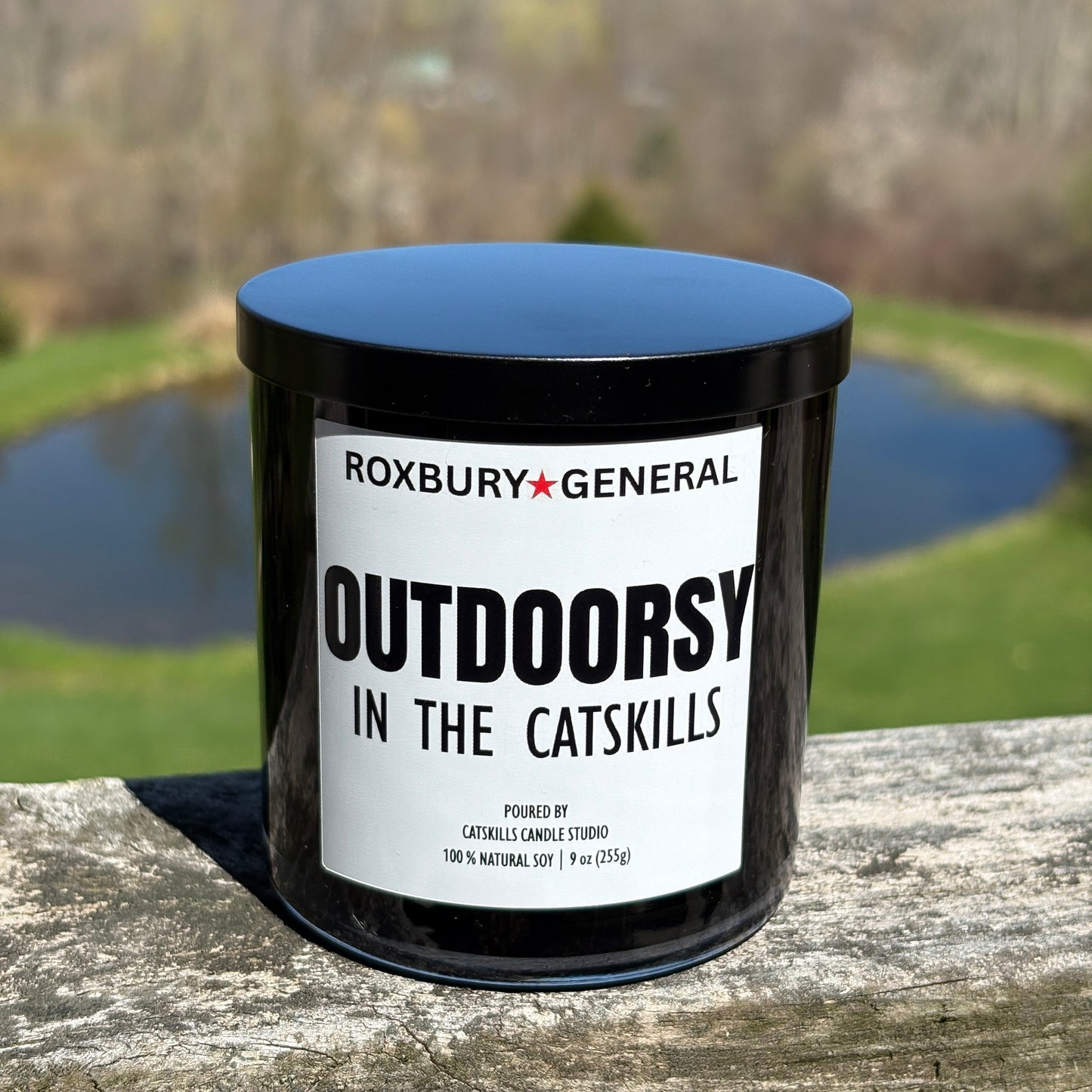 Outdoorsy forest scented hand poured candle in 9 oz, black glass container with black metal lid.