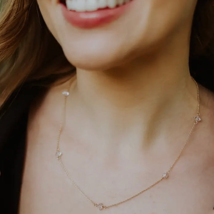 Herkimer diamond necklace with 5 Herkimer stones on 14K gold filled chain shown on woman's neck